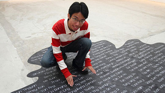 Photograph of a close-up view of the blender spill artwork pasted on the floor, incorporating names of the exhibitors of Random Blends 2011.
